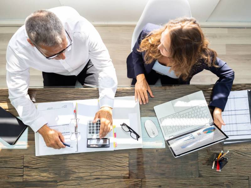 Business man and woman working at a desk planning a cyber security assessment for an Australian business
