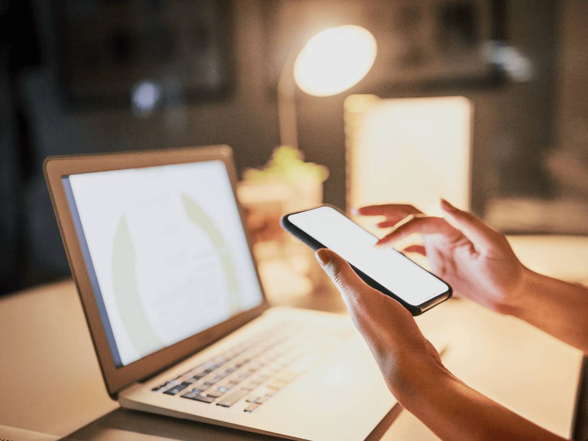User using a smart phone and laptop