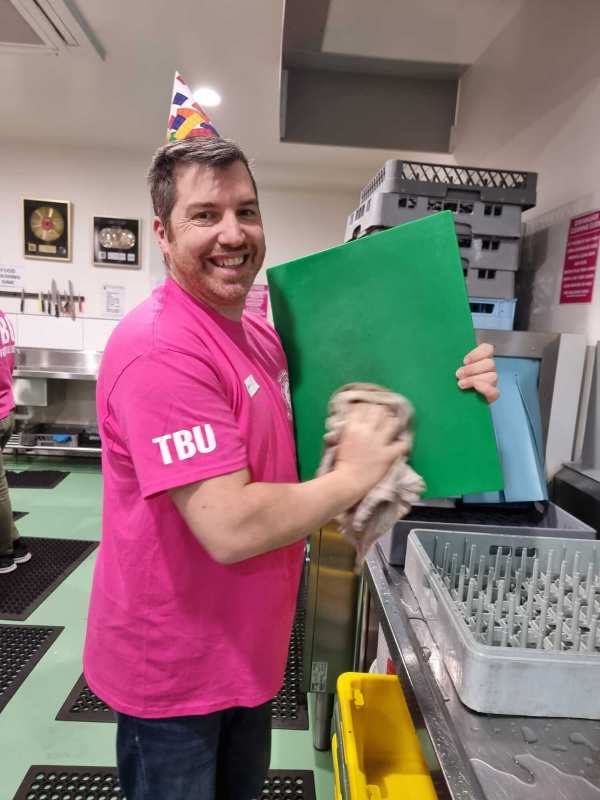 Sentaris owner volunteering at food bank in the kitchen washing dishes